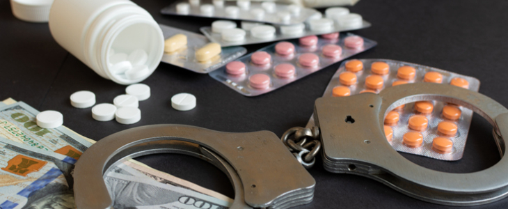 Drugs, handcuff, and money on a table to represent drug crimes