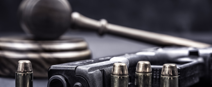 Gun with bullets and a gavel and mallet to represent federal weapons charges