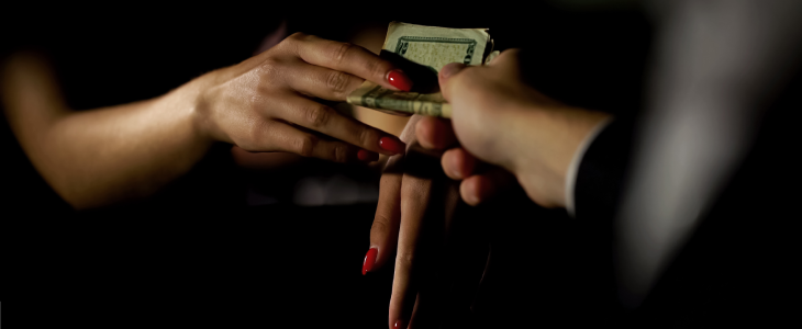 Man handing cash to a women in prostitution