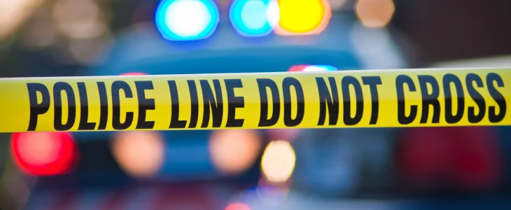 Police crime tape across a crime scence